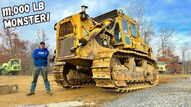 Matt standing beside a huge yellow Caterpillar D9 bulldozer