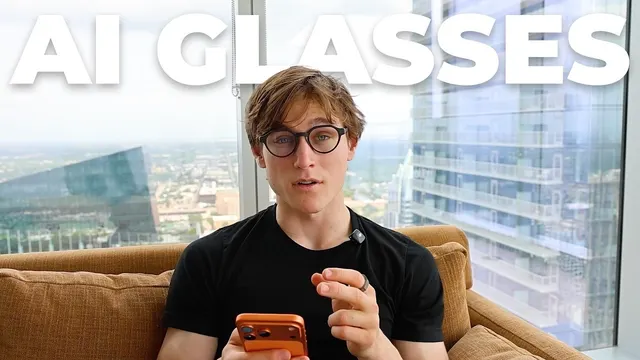 Jon Law in glasses on a sofa by a city-view window, "AI glasses"