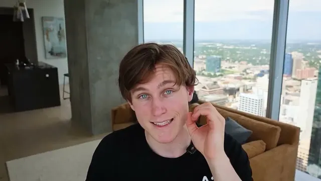 Jon Law smiling in a high-rise apartment with a city view