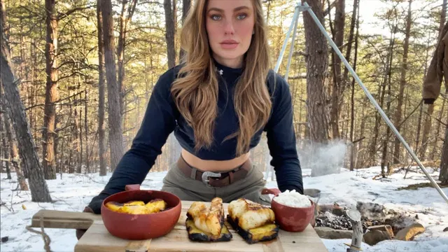 Heidi with a campfire meal on a table in the snowy woods